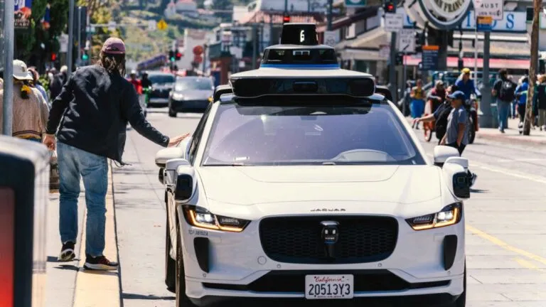 Vehículo autónomo de Waymo circulando en calles urbanas de Estados Unidos con diseño futurista y ambiente tecnológico