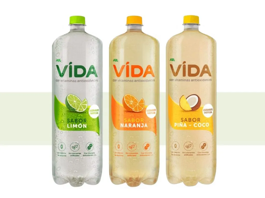 Botellas de Agua VIDA en sus tres sabores —naranja, limón y piña-coco—, representando frescura, bienestar y estilo de vida saludable.
