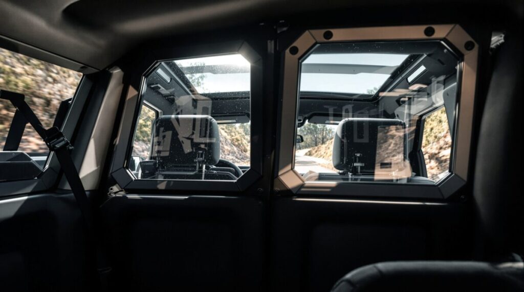 Vista interior de un vehículo blindado con ventanas de vidrio balístico y refuerzos estructurales en marcos y pilares, mostrando continuidad entre las zonas opacas y transparentes.