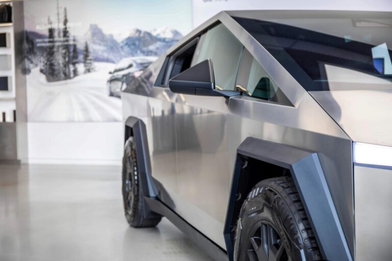 Fotografía de una Tesla Cybertruck detenida en un taller, revisada por técnicos, con foco en seguridad automotriz