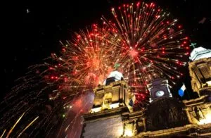 Personas celebrando Año Nuevo en playas mexicanas y pueblos mágicos, con fuegos artificiales y paisajes festivos