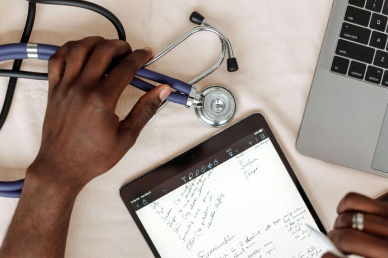 Profesional de la salud trabajando con tecnología digital, estetoscopio y tablet, reflejando la innovación de startups de salud en Estados Unidos