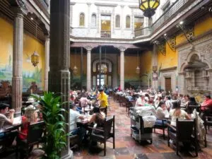 Fachada moderna de hotel en Ciudad de México con banderas internacionales, simbolizando turismo por el Mundial 2026