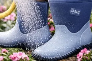 Primer plano de unas botas invierno cómodas impermeables con sello RHS en terreno húmedo Reino Unido