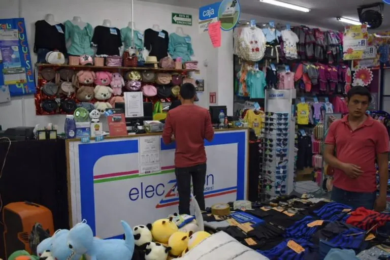 Interior de tienda en Parral con clientes y productos, reflejando actividad comercial en riesgo