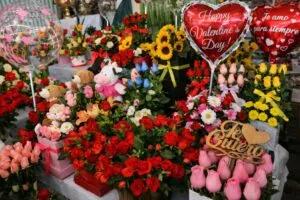 Pareja comprando flores y chocolates en una tienda durante el Día del Amor y la Amistad, reflejando derrama económica