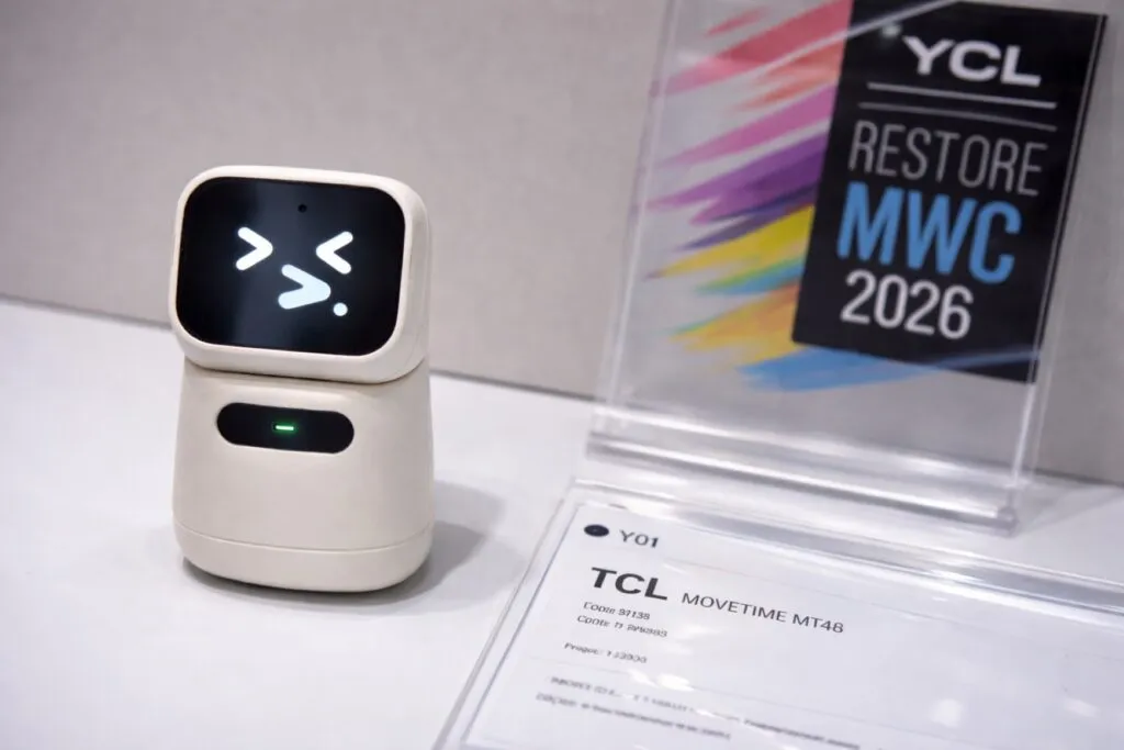 Niño usando tecnología infantil inteligente con TCL Tbot y reloj conectado en escritorio con IA