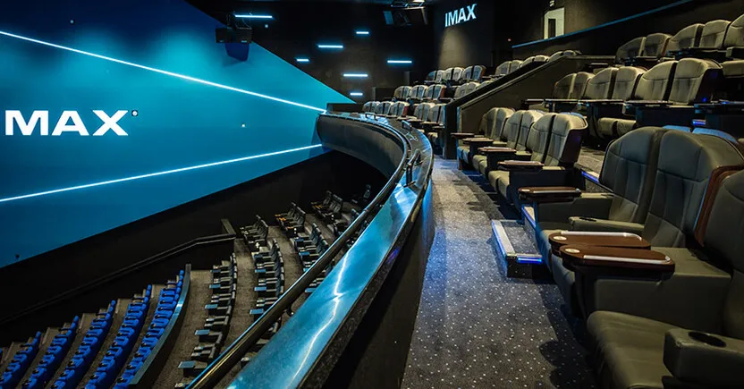 Sala IMAX moderna con pantalla monumental y experiencia cinematográfica inmersiva de última generación