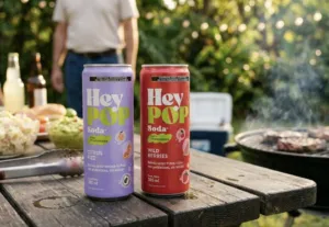Latas de HeyPOP sabor Wild Berries y Citrus Fizz sobre una mesa en un entorno lifestyle contemporáneo.
