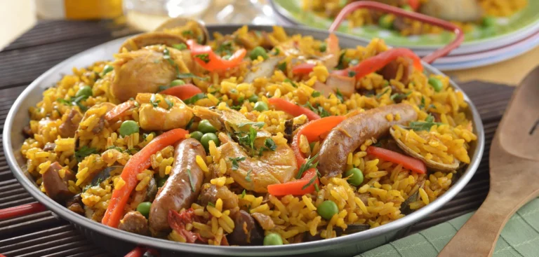 Paella tradicional española preparada en una gran sartén con arroz, mariscos y azafrán.