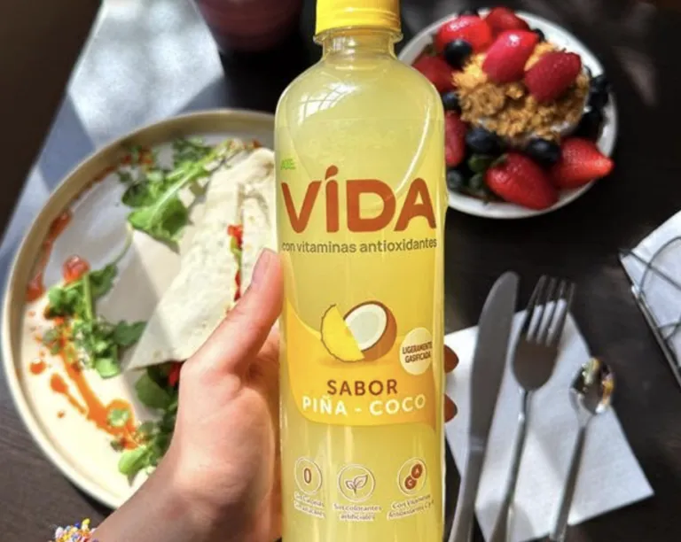 Agua VIDA con Antioxidantes junto a un plato balanceado con verduras, proteína y frutas.
