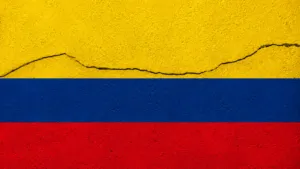 Bandera de Colombia sobre una superficie con una grieta que representa el impacto de un sismo