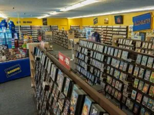 Fachada de un Blockbuster clásico con clientes entrando a rentar películas y videojuegos.