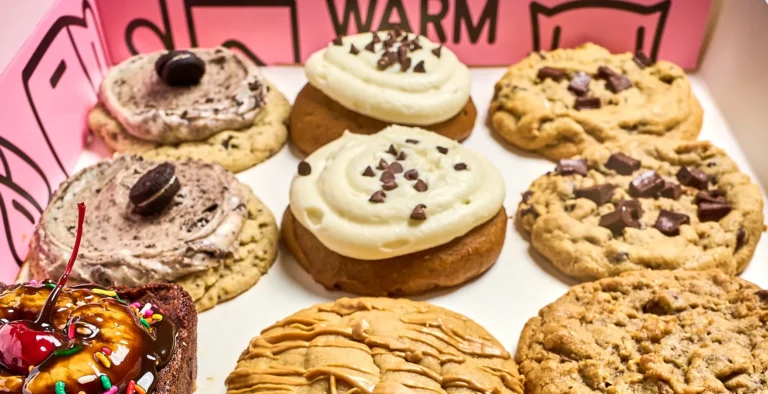 Exterior de Crumbl Cookies en Roma Norte con clientes haciendo fila y las características cajas rosas.