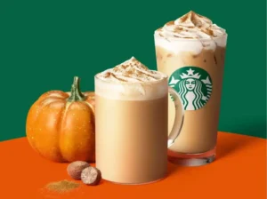 Pumpkin Spice Latte sobre una mesa con elementos otoñales mientras al fondo todavía se observa un ambiente veraniego.