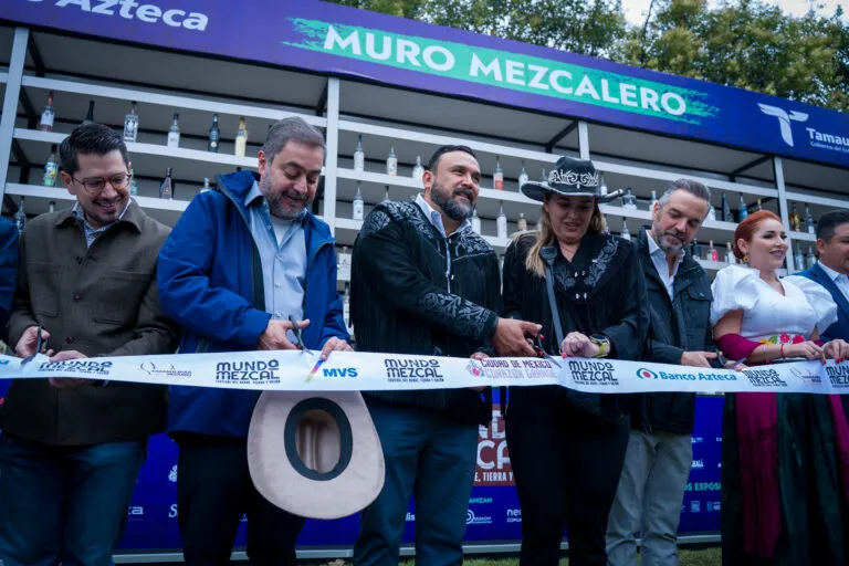 Participantes realizan el corte de listón de Mundo Mezcal frente al Muro Mezcalero durante el festival en Campo Marte.