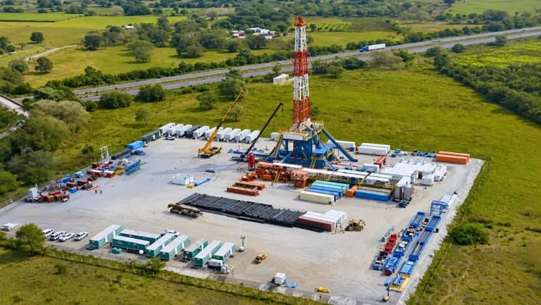 Cultivos de caña de azúcar junto a una instalación industrial que representa el proyecto de Pemex para producir combustible sostenible de aviación.